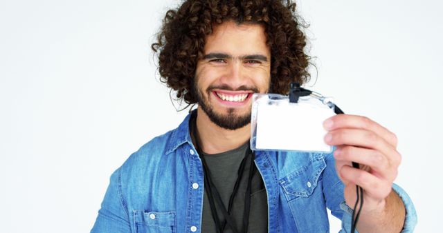 Happy Young Man Displaying ID Badge in Denim Jacket - Download Free Stock Images Pikwizard.com