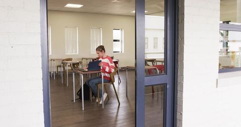 Girl Engaged with Tablet in Empty Classroom Setting