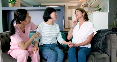Senior Woman with Nurse and Friend in Living Room Discussing Health