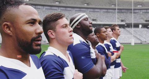 Rugby team standing with hands on chests before match at stadium showing unity