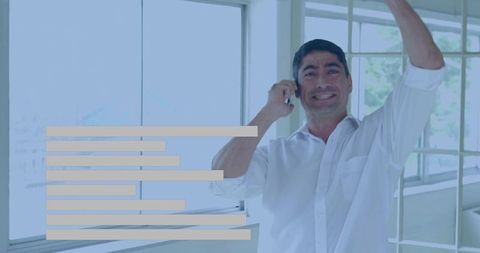 Smiling executive celebrating success while talking on phone in bright modern office
