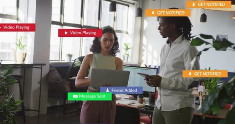 Collaborating professionals using laptop and phone in modern office with app notifications