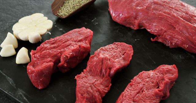 Fresh Raw Beef Cuts on Dark Cutting Board with Garlic and Rosemary - Download Free Stock Images Pikwizard.com