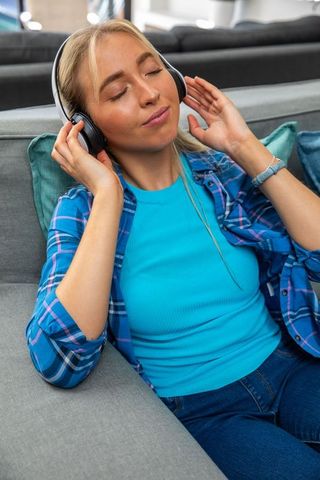 Woman Relaxing with Headphones Near Brightly Colored Pillows
