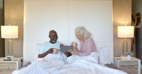 Senior Couple in Bed Enjoying Coffee and Tablet Time