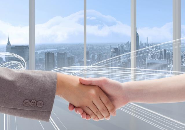 Digital composition of business executives shaking hands against cityscape in background