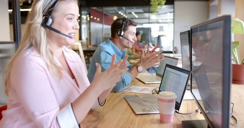 Team of Colleagues using Headsets for Collaboration in Modern Office