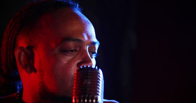 Close-up of male singer with vintage microphone in dark studio - Download Free Stock Images Pikwizard.com