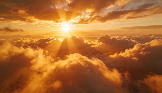 Golden sunrise above clouds with dramatic crepuscular rays and glowing aerial skyscape
