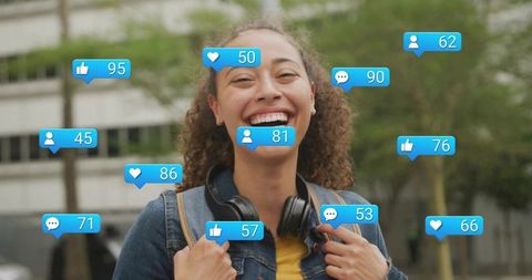Smiling college student wearing headphones surrounded by social media reaction bubbles