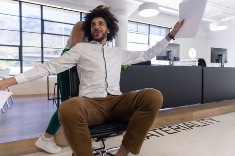 Cheerful Coworkers Enjoying Office Play in Modern Workplace