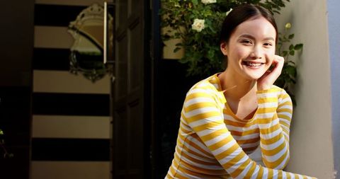 Happy Woman Relaxing on Cozy Porch Surrounded by Botanical Elements