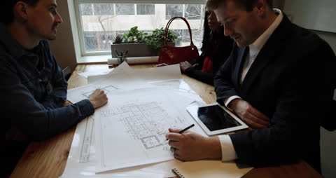 Architect Team Discussing Blueprints in Modern Office Collaboration