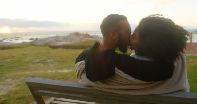 Romantic diverse couple embracing and kissing close to beach at sunrise, copy space. Summer, vacation, romance, love, relationship, free time and lifestyle, unaltered.