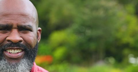 Senior Man Smiling in Lush Garden - Vibrant Outdoor Portrait