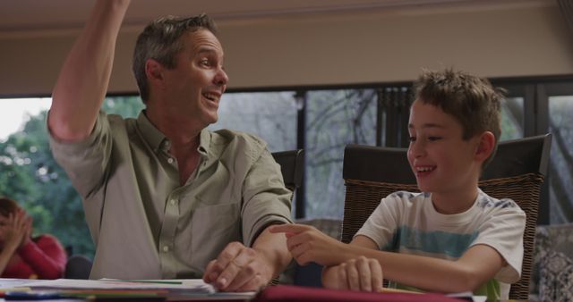 Father and Son Smiling and Helping with Homework at Home - Download Free Stock Images Pikwizard.com