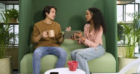 Diverse Coworkers Collaborating and Discussing Ideas in Office Lounge