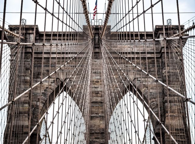 This visually striking close-up showcases the intricate suspension cables and architectural details of the Brooklyn Bridge's towers. Perfect for use in articles or designs highlighting New York City's iconic landmarks, engineering marvels, or architectural achievements.