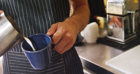 Barista Preparing Coffee in Blue Cup at Cafe Counter