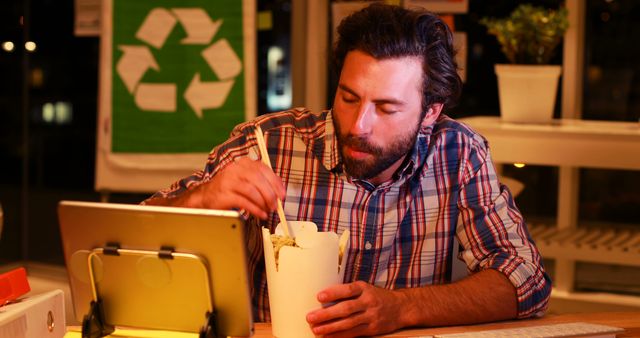 Man Enjoying Takeout Noodles While Working at Night in Eco-Friendly Office - Download Free Stock Images Pikwizard.com