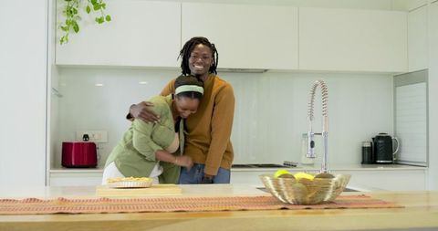 African American Couple Laughing and Embracing at Modern Bright Minimalist Kitchen Island