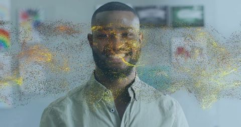Smiling man standing with gold particle swirl and abstract art backdrop