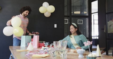 Colleagues Clearing Up After Baby Shower Celebration in Office
