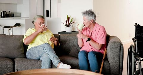 Happy Senior Lesbian Couple Enjoying Coffee and Conversation at Home