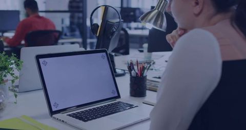 Businesswoman Focusing on Blank Laptop Screen in Office Workspace