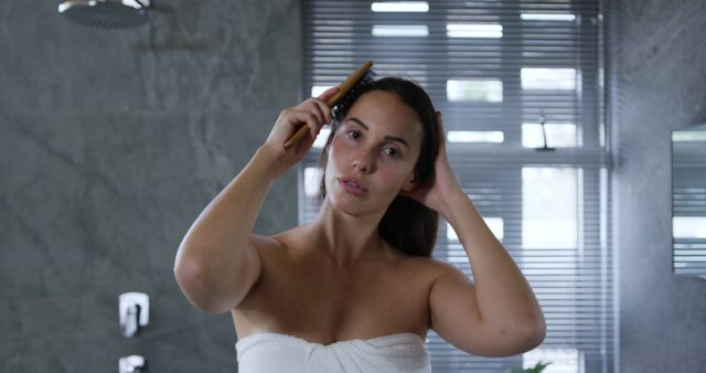 Woman Combing Hair in Modern Bathroom with Towel Wrapped Around - Download Free Stock Images Pikwizard.com