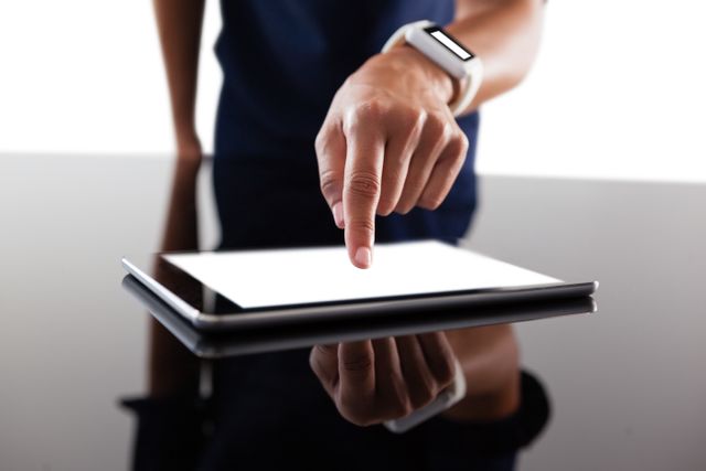 Businesswoman interacting with digital tablet wearing smartwatch. Ideal for technology, business, and modern workplace themes. Useful for illustrating concepts of digital interaction, professional tools, and tech-savvy environments.