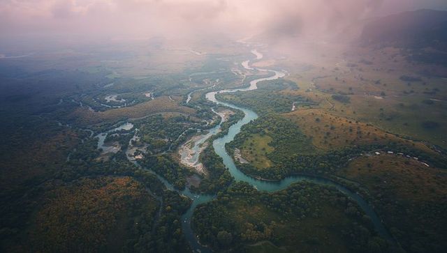 Aerial view of meandering river in tranquil valley landscape