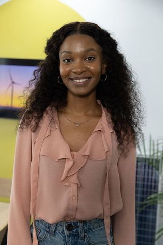 African american professional smiling in modern office with renewable energy display
