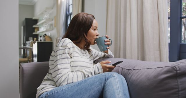 Woman Relaxing with Coffee and Remote Control at Home - Download Free Stock Images Pikwizard.com