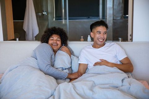 Interracial Couple Enjoying Cozy Morning in Modern Bedroom