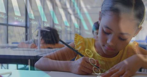 Focused mixed ethnicity girl writing in classroom for education theme