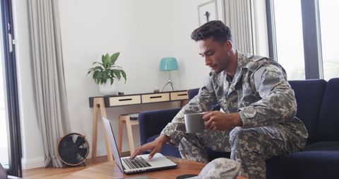 Soldier Relaxing at Home with Laptop and Coffee