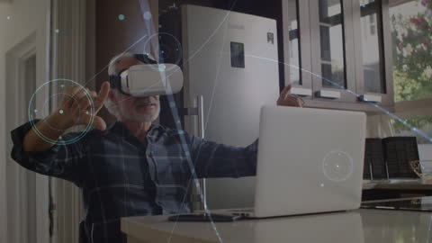 Senior Man Using VR Headset and Laptop with Data Graphics
