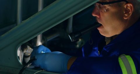 Focused mechanic inspecting vehicle interiors in garage