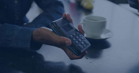 Handing portable card terminal for contactless payment on glossy cafe counter with coffee