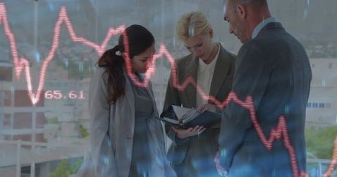 Three executives collaborating reviewing planner with falling stock chart and city skyline