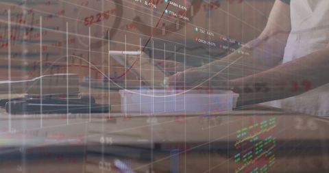 Hands placing container on kitchen counter with stock market overlay for business concept