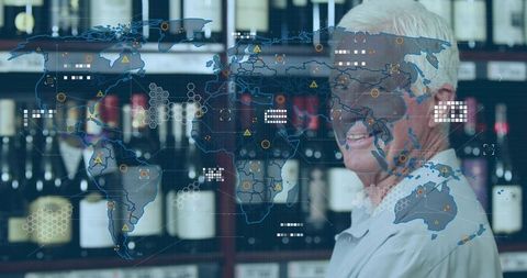 Standing senior shopkeeper wearing glasses with ar world map overlay in wine shop