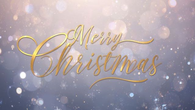 Merry christmas gold calligraphy on glittering bokeh background with snowflakes