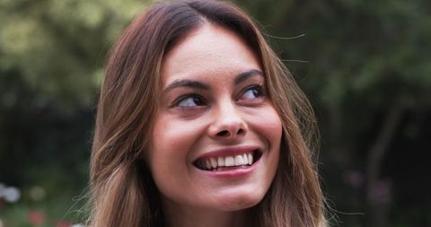 Woman Smiling Amidst Lush Garden Tranquility