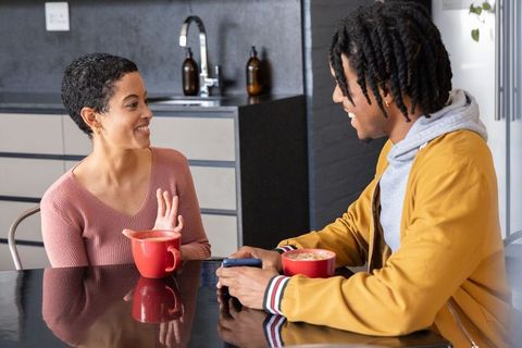 African american couple chatting over coffee at modern kitchen island, casual conversation