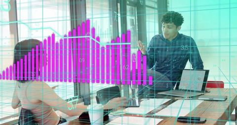 Team collaborating while analyzing interactive purple bar chart in modern glass office