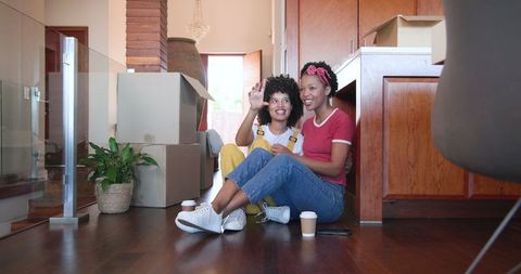 Smiling Couple Bonding with Coffee Post-Move Amidst New Home Setting