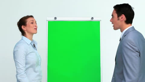 Professionals Discussing Strategy Next to Green Screen Board
