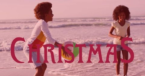 Siblings Playing with Beach Ball During Christmas at Sandy Beach